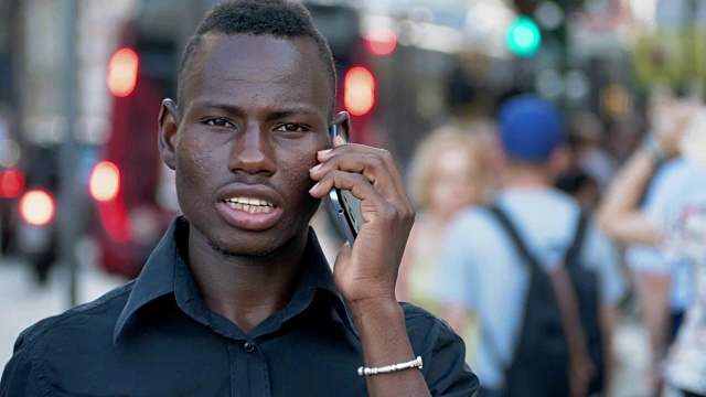 一幅非洲黑人青年在城市里打电话的肖像视频下载