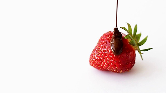 草莓和巧克力，巧克力流下来。一个白色背景的巧克力草莓。慢动作视频素材