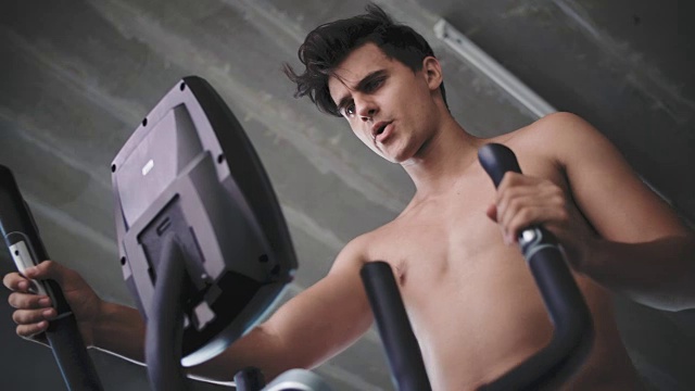 在健身房里用交叉训练器的男人视频素材