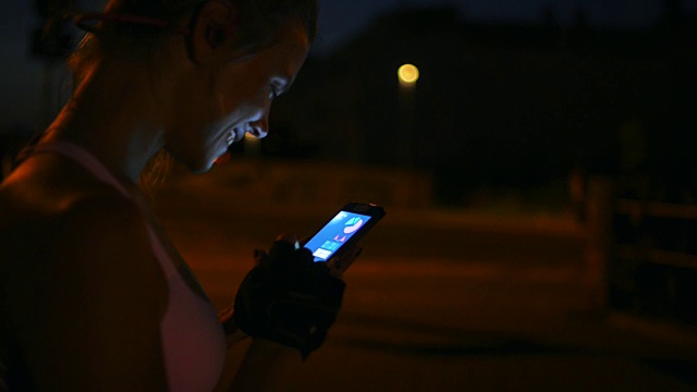 健身后使用手机追踪应用的女性。视频素材