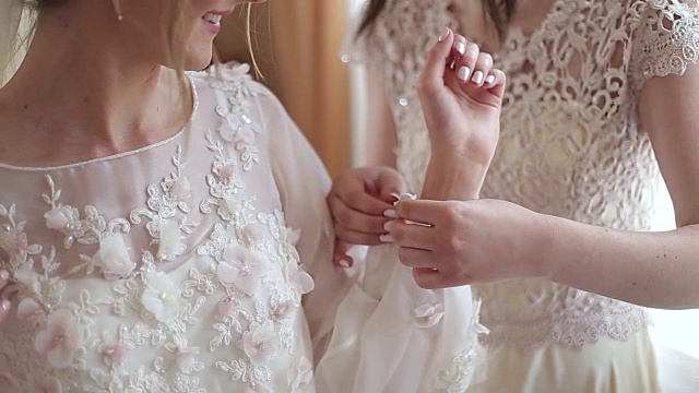 婚纱上的扣子是由伴娘系住的。清晨的新娘聚会视频下载