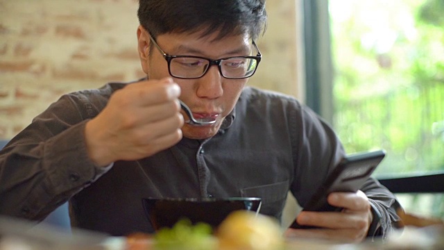 亚洲男人一边吃早餐一边看手机视频下载