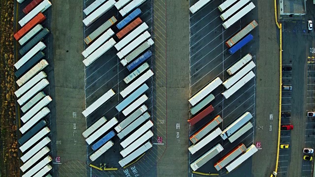 从上到下的无人机拍摄一排排的集装箱和卡车拖车在巨大的船坞视频素材