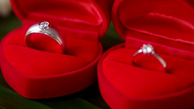 漂亮闪亮的结婚戒指与红盒子为新娘和新郎。视频下载