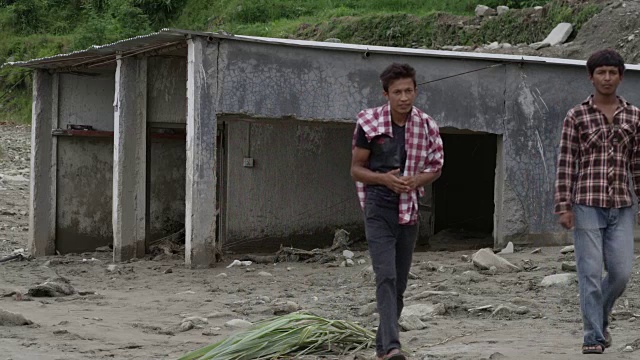 尼泊尔博卡拉——2015年8月2日:被山体滑坡摧毁的车库，三名男子走过视频下载