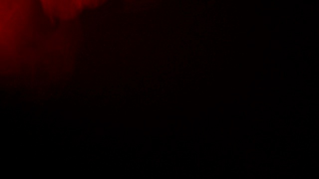 抽象的红色烟雾像云的波浪效果在黑色的背景，流动视频素材