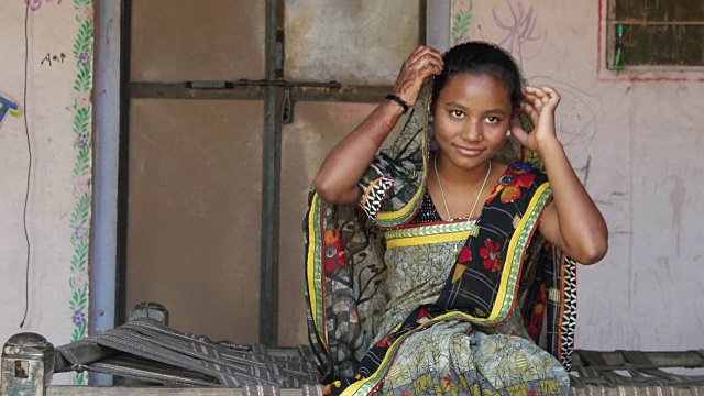 中景的印度少女坐在家里与纱丽服装传统合十礼蒙着头看着相机加入指甲花纹身的手问候微笑内容调整静态视频素材
