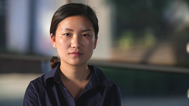 严肃的年轻中国女人的特写慢镜头，4k视频素材