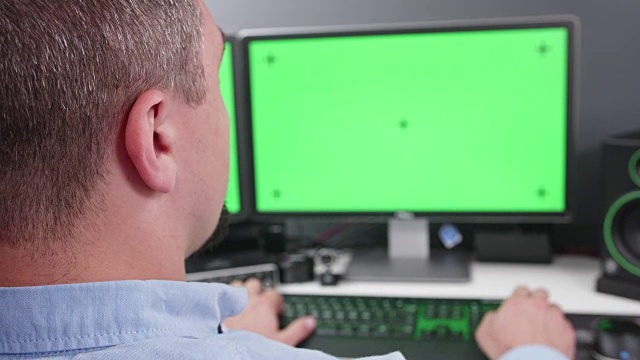 FPV特写的人在办公室工作的双显示器计算机与绿色屏幕的色度键视频下载