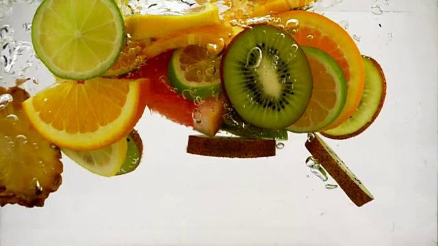 多种水果的鸡尾酒，水果的碎片落入水中溅起和泡沫，慢镜头特写视频素材