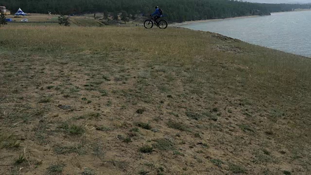 胖自行车或胖轮胎的自行车在夏天开车穿过山丘。视频下载