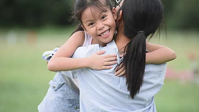 可爱的亚洲女孩跑向她的妈妈，她拥抱她的感情视频素材