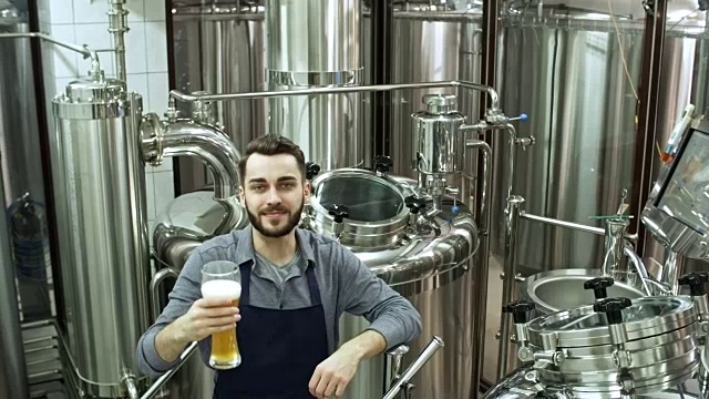 啤酒厂老板拿着一杯啤酒摆姿势视频下载