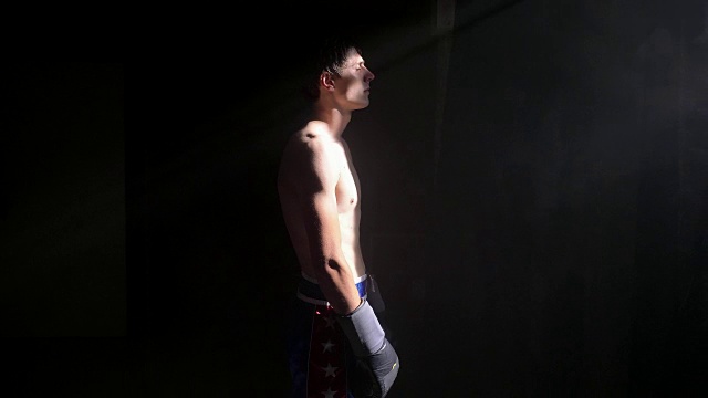 赤裸上身的拳击手站在烟雾弥漫的黑暗房间里等着打架视频素材