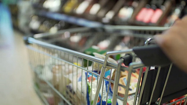 中年白人女性顾客推着购物车通过当地超市的农产品部视频素材