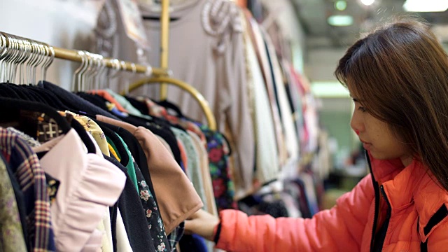 女人与冬季衣服寻找t恤在商店视频素材