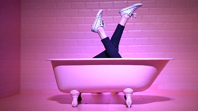 在粉色浴缸里玩得开心的女人腿视频素材