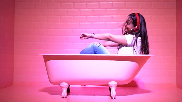 在粉色浴缸里开心跳舞的女人视频素材