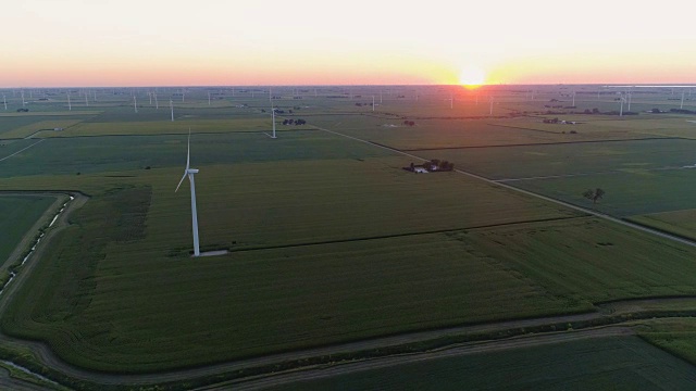 日落时分，在乡间玉米地和风力涡轮机上的空中飞行视频素材