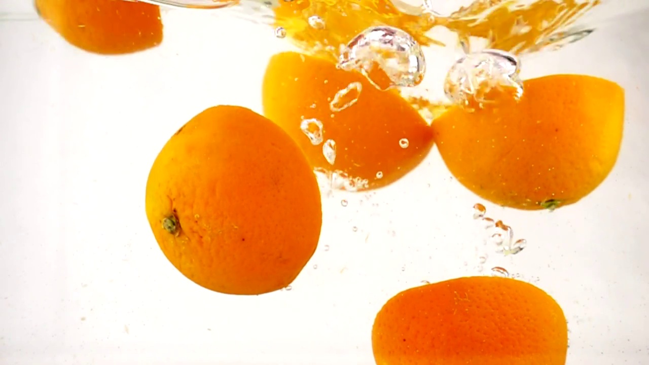 多汁的橙汁浸泡在水中，慢动作特写视频素材