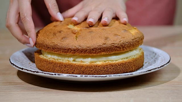 女糕点师正在用奶油和香草奶油做海绵蛋糕视频下载