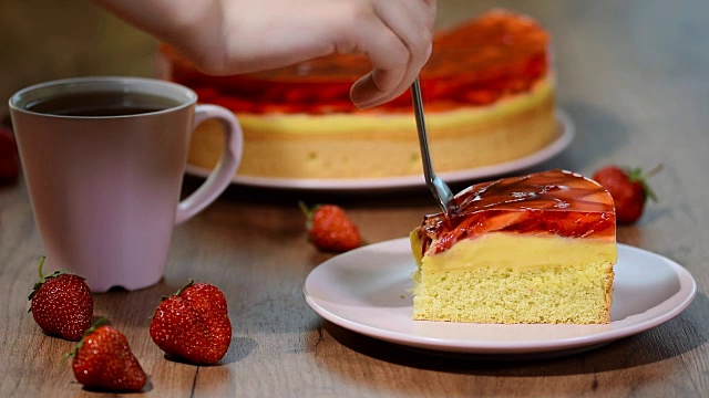 粉红色盘子上放着一块草莓果冻蛋糕。视频下载
