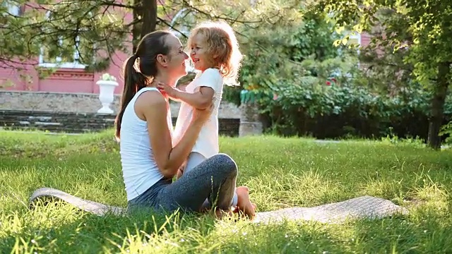 快乐的家庭年轻的运动母亲和可爱的小女儿在户外玩视频素材