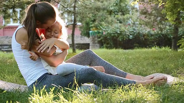 快乐的家庭年轻的运动母亲和可爱的小女儿在户外玩视频素材