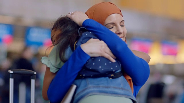 中东的母亲和小女儿奔向对方，在机场候机楼拥抱。视频下载