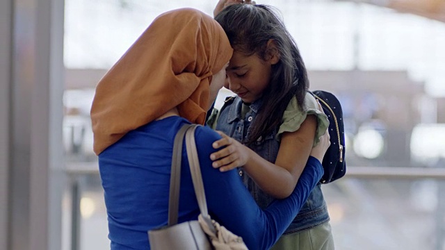 中东女孩在机场候机楼拥抱她的母亲。视频下载