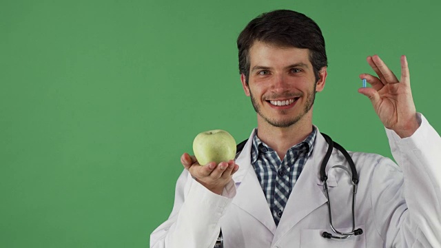 兴高采烈的男医生拿着维生素片和一个苹果视频素材
