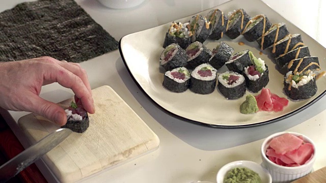 寿司师傅在新鲜寿司卷上撒芝麻的跟踪镜头视频素材