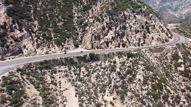 下面是鸟瞰图，两辆摩托车在加州拉Cañada福林特里奇蜿蜒的高速公路上快速行驶视频下载