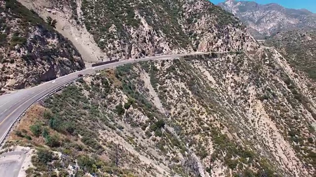 加利福尼亚拉Cañada福林特里奇的弯曲山路跟踪车辆的上升空中镜头视频下载