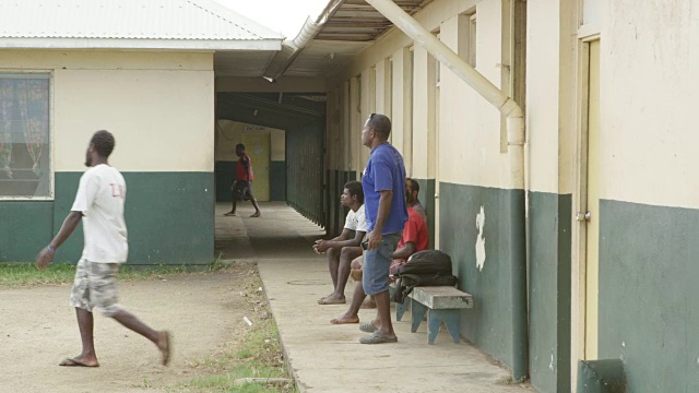 瓦努阿图- 2015年3月30日:一群男子坐在医院外视频素材