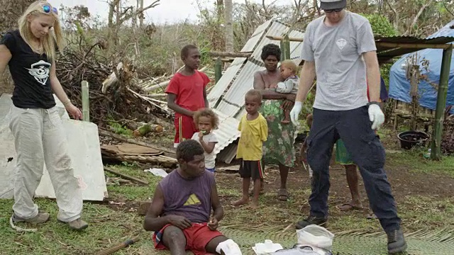 2015年3月31日，瓦努阿图:医疗队结束治疗，患者家属站在一旁观看视频下载