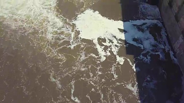 鸟瞰图。瀑布和老水坝的镜头。夏天的风景。摄像机从河的上游一侧移动，飞过大坝视频素材