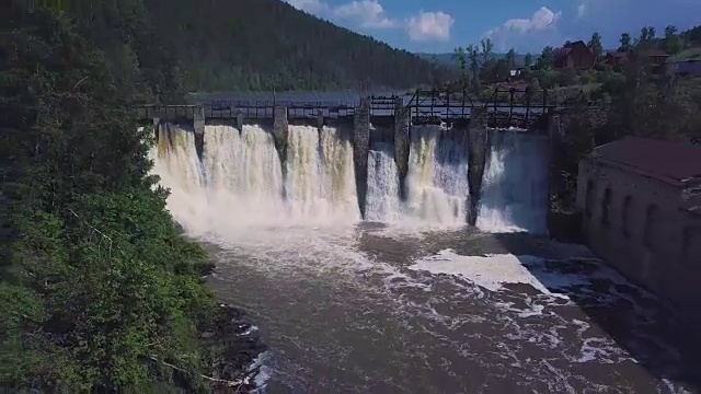鸟瞰图。瀑布和老水坝的镜头。夏天的风景。摄像机从大坝前后移动，展现了整个地形视频素材