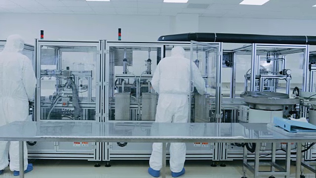 制造实验室的科学家在保护工作服与工业高精度3D打印机械工作。制造制药/技术/工业产品。视频素材
