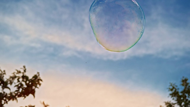 SLO MO大泡泡漂浮在外面的空气中，蓝色的天空为背景视频素材