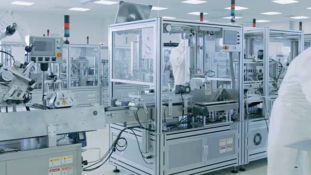 在无菌高精密制造实验室里，科学家们穿着防护服使用计算机和显微镜，做制药、生物技术和半导体研究。视频素材
