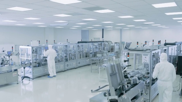 无菌高精密制造实验室，科学家在保护工作服打开机械，使用计算机和显微镜，做制药，生物技术和半导体研究。视频素材