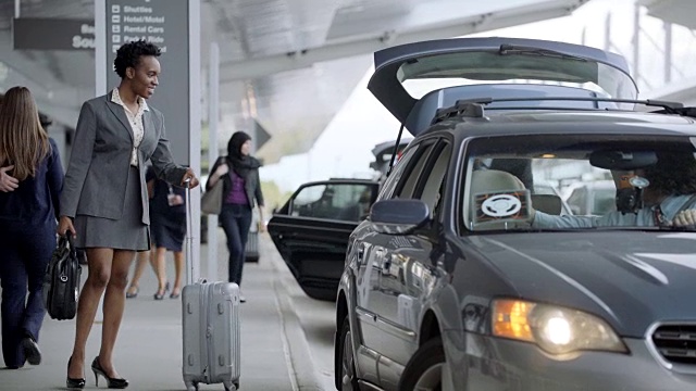 出租车载着两个不同的商业伙伴离开机场，空乘人员紧随其后。视频素材