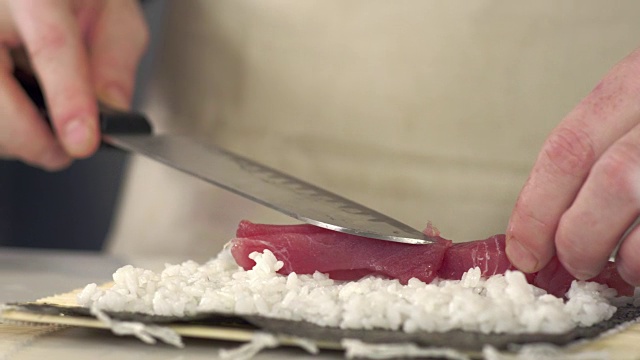 寿司师傅在新鲜寿司卷上撒芝麻的跟踪镜头视频素材