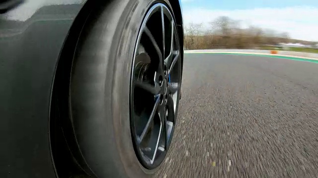 在赛道上快速行驶，车轮旋转的汽车景色视频下载