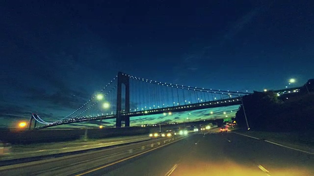 黄昏时分行驶在维拉萨诺海峡大桥下的Belt Parkway上。纽约布鲁克林。视频素材