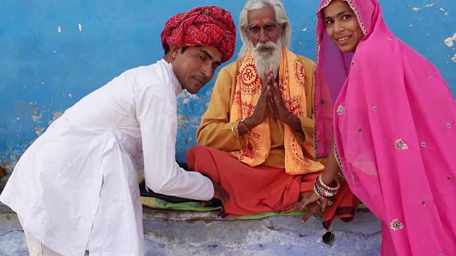 在拉贾斯坦邦的普什卡，一对戴着粉色、白色和红色头巾的丈夫和妻子在寻求印度牧师的祝福视频下载