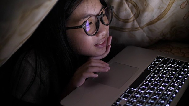 聪明的年轻女孩在她的卧室晚上视频素材