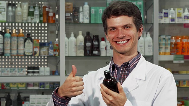 愉快的药剂师在药店工作时竖起大拇指视频下载