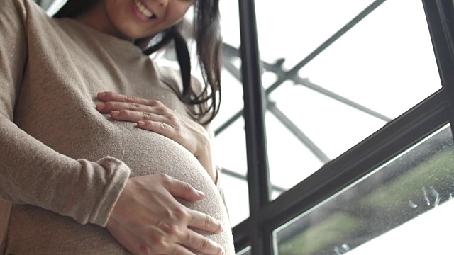 孕妇轻轻抚摸着肚子，怀孕/分娩视频素材